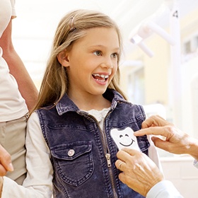 young girl with tooth sticker