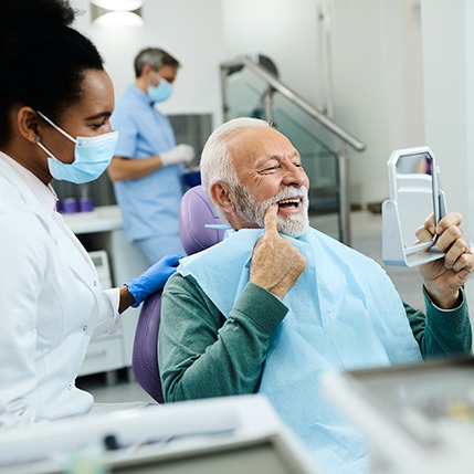 a patient inspecting his smile in a mirror