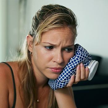 woman with icepack on cheek