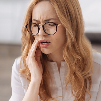 woman with glasses in pain