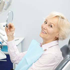 senior woman smiling after getting dental implants