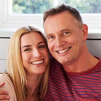 man in striped shirt hugging woman