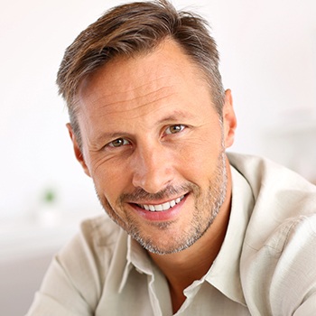 man in tan shirt smiling