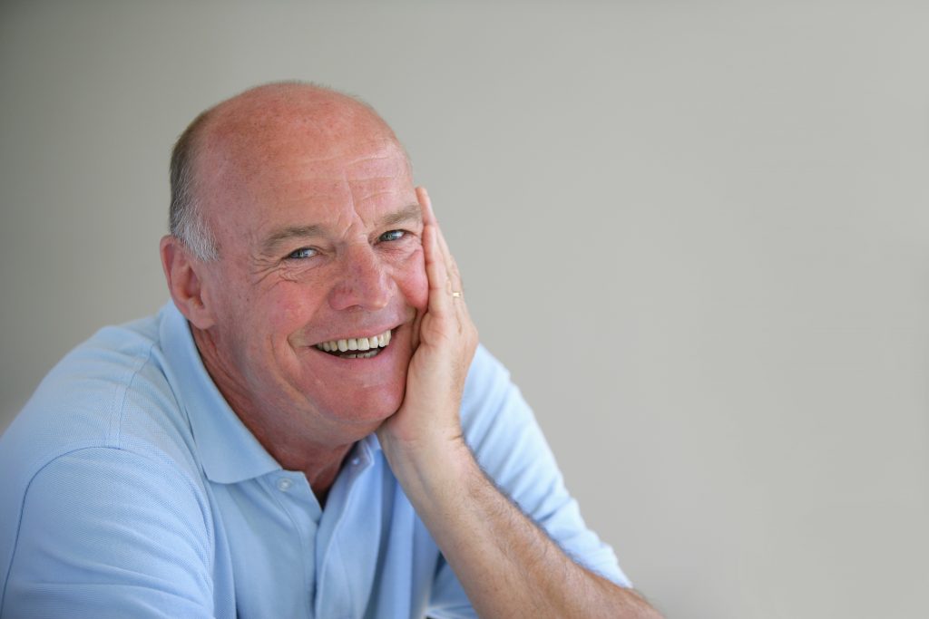 older man blue shirt smiling