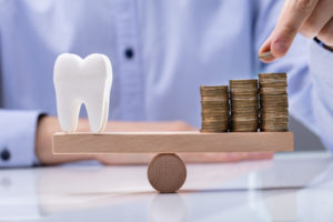 Man Stacking Coins on Seesaw with Tooth