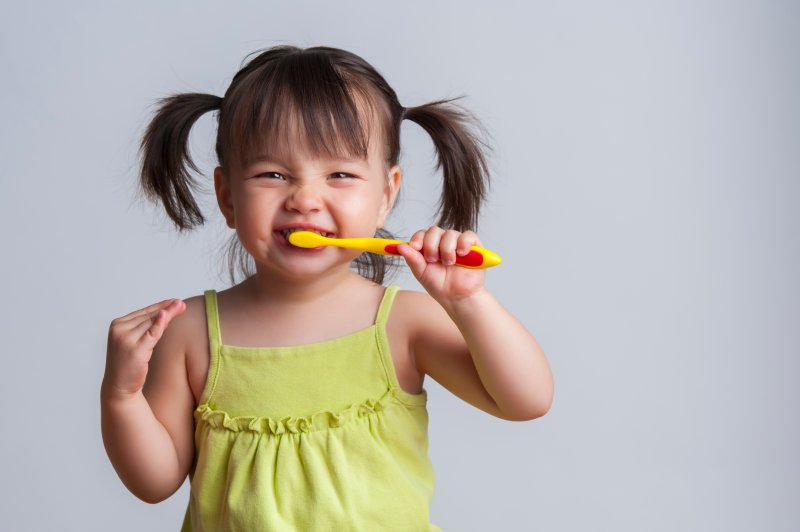 A little girl using oral health products