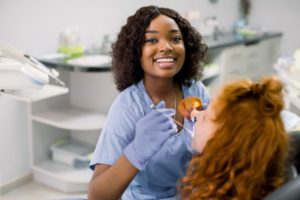a dental assistant happily helping a patient