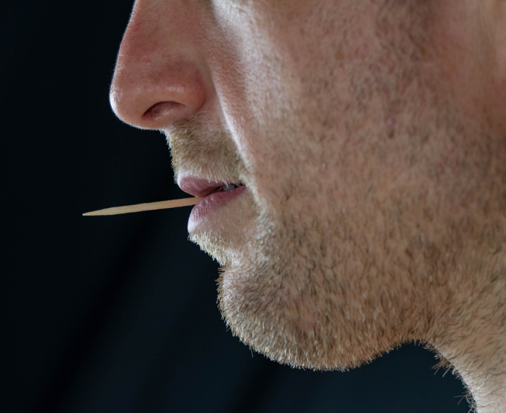 Close up of man's mouth with toothpick
